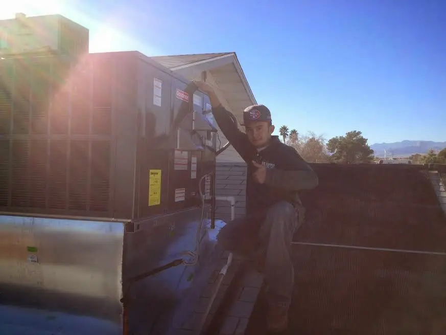 HVAC technician performing Air Duct Repair on a rooftop unit in Summerfield